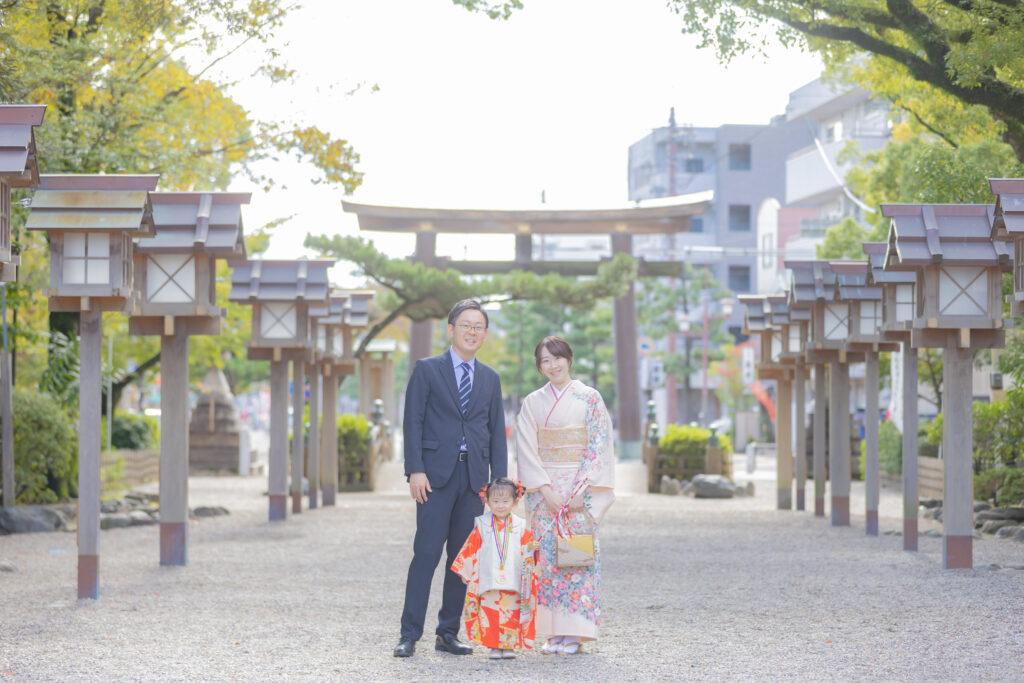 豊國神社の入口にそびえる大きな鳥居の前で撮影した七五三の家族写真